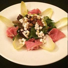 Goat Cheese Salad: Belgium endive, micro greens, crumbled goat cheese, Prosciuto di Parma, roasted pine nuts, pistachios, and pecans topped with an orange blossom vinaigrette   